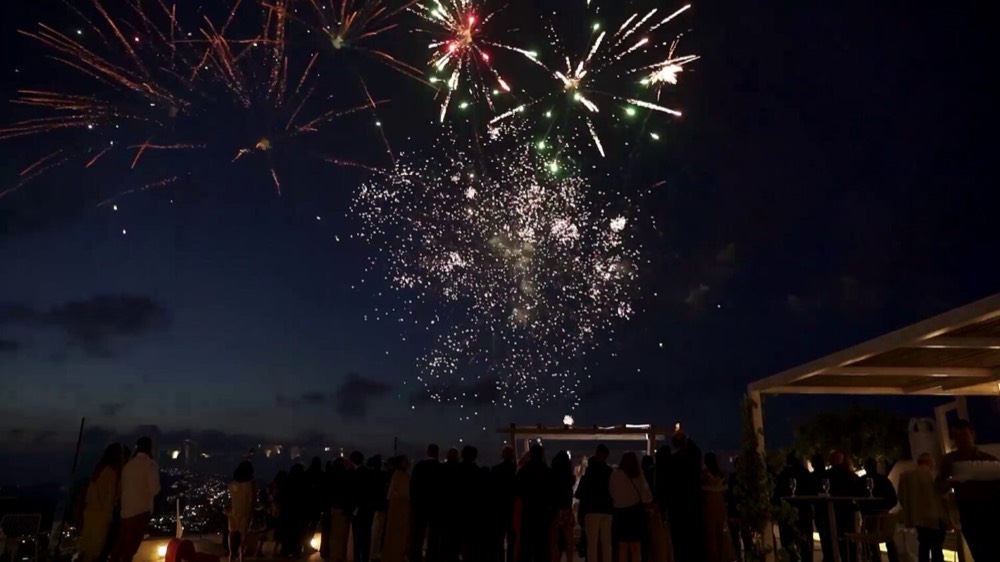 Aerial fireworks above a terrace of guests
