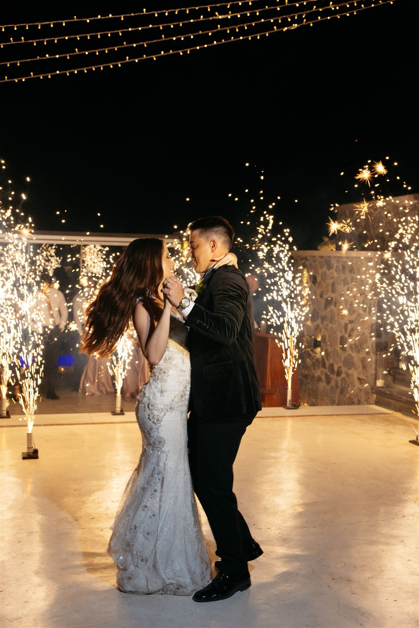 Ground fountains at a first dance under string lights