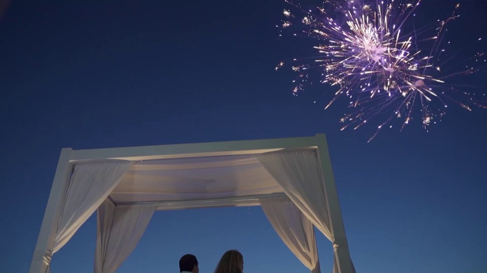 Lilac aerial burst above a white gazebo at dusk